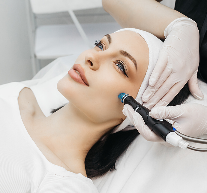 A patient receiving a laser facial treatment from a cosmetology professional in a clinical setting.