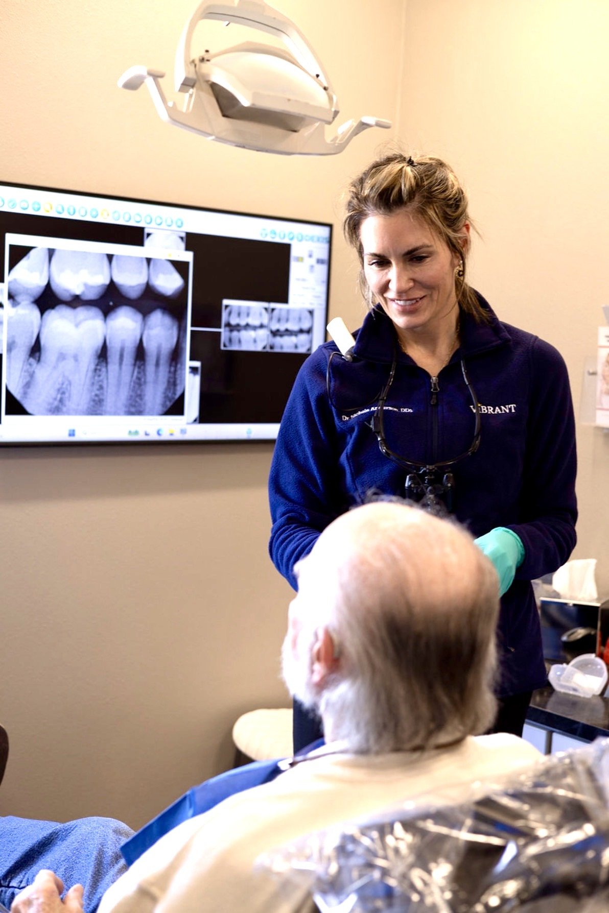 A cosmetic dentist in Colorado Springs, Dr. Nichole Anderson, discusses dental X-rays with a patient in a treatment room.
